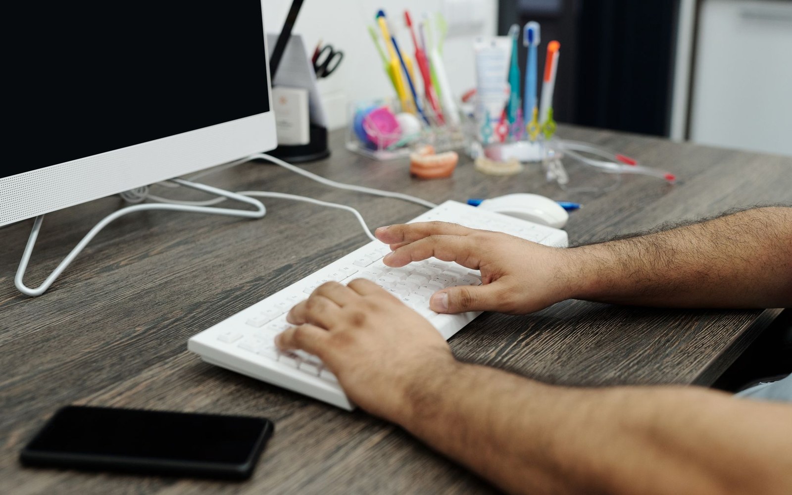 A desk with a mouse and pencils